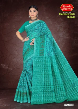 Woman draped in a turquoise Florence Varli Chokda saree by Sharda Lifestyle, featuring intricate tribal and geometric motifs, a matching blouse, and accessorized with oxidized silver jewelry, posed against a textured brown backdrop.