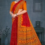 Woman in red and yellow Maan Bawari Checks saree with traditional bandhej print and detailed ethnic border by Sharda Sarees