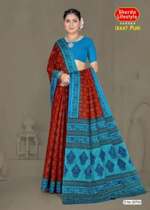 Model wearing rust red and turquoise blue Ikkat Puri saree with intricate traditional motifs, styled with silver jewelry