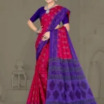 Model wearing a magenta and violet Ikkat Puri saree with bold traditional patterns and temple motif pallu, paired with statement silver jewelry.