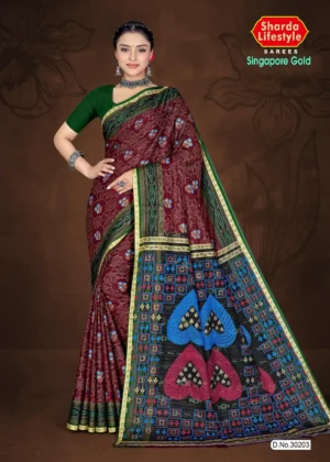 Model wearing maroon and green Singapore Gold saree with floral print and multicolor pallu featuring heart motifs and geometric designs